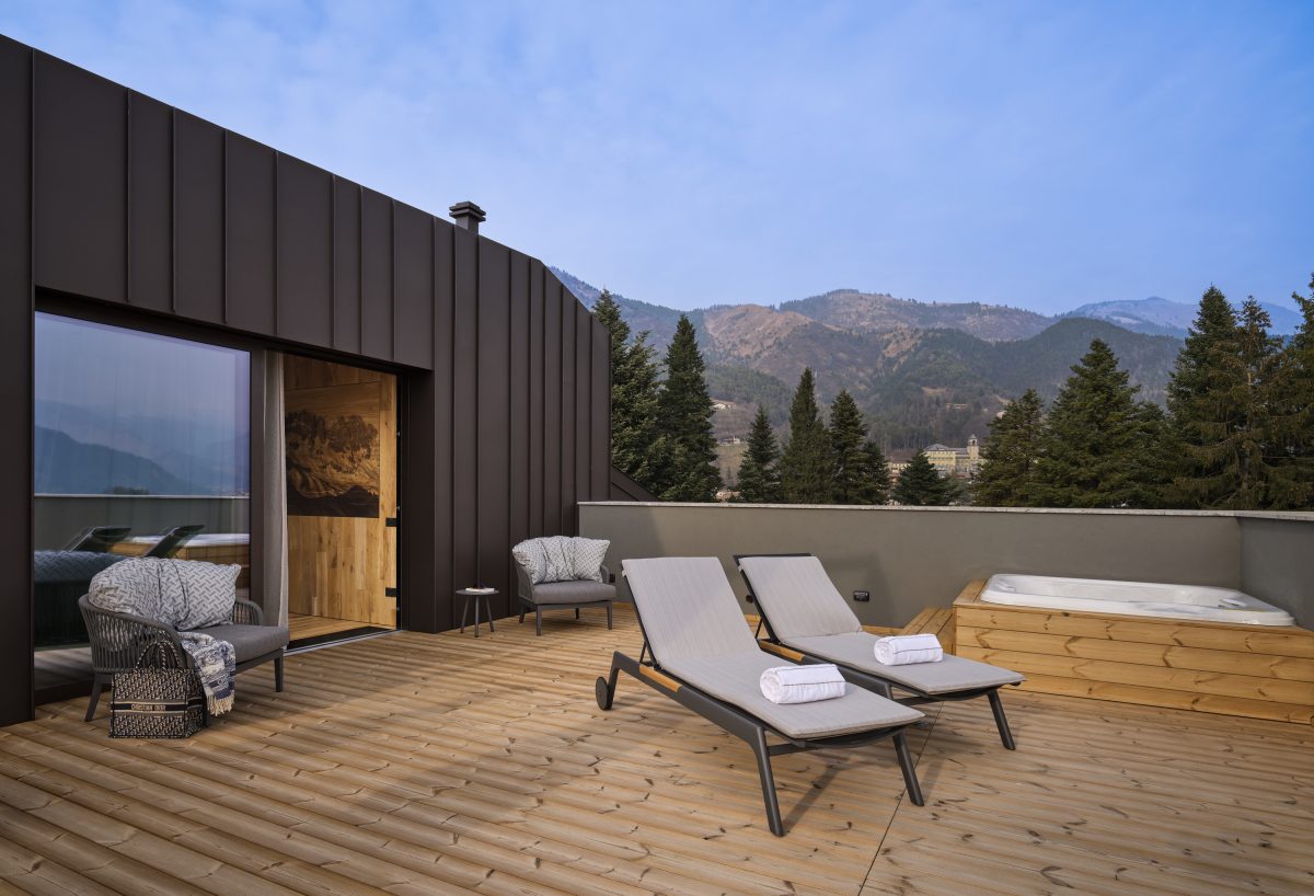 Terrazza panoramica della Rooftop Suite con lettini e jacuzzi privata vista sulle Prealpi Orobie — Collina Luxury Relais