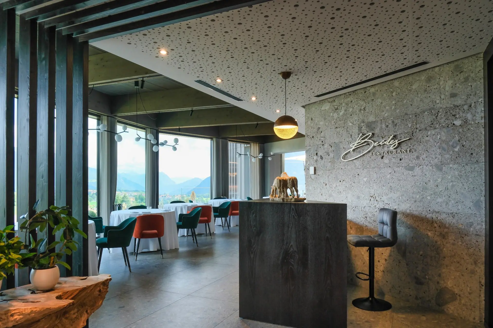 Ingresso e sala del Beides Restaurant con tavoli, vetrate panoramiche sulla vallata e insegna a parete — Collina Relais Clusone
