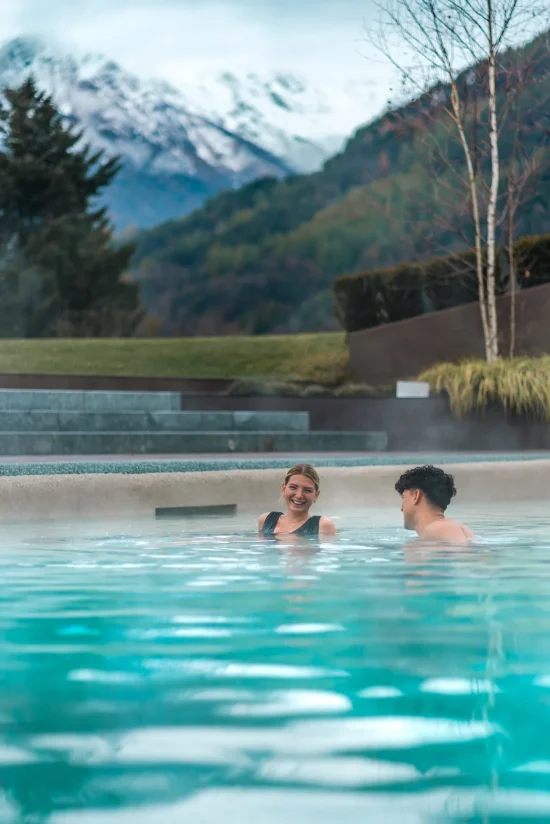 Coppia nella piscina esterna riscaldata con vapore e vista sulle Orobie innevate alla My Purity SPA del Collina Luxury Relais di Clusone