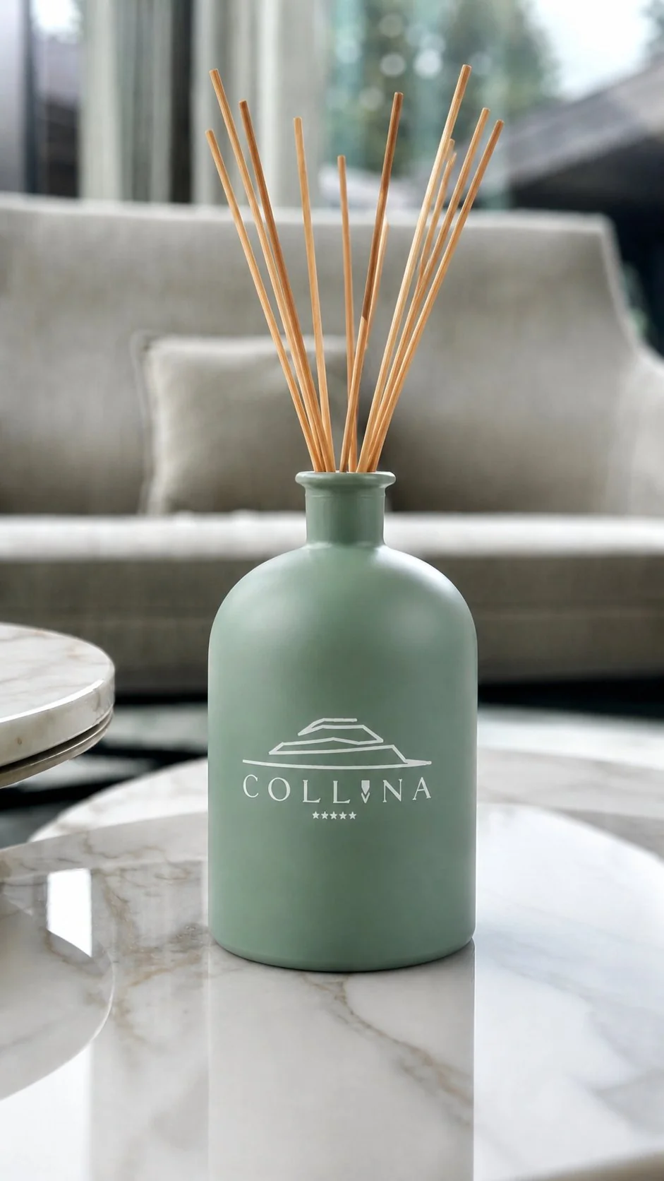 Collina 1L home diffuser with reed sticks on white marble table in the lounge area