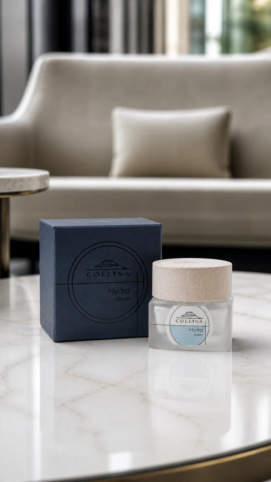 Hydra Cream Collina con scatola blu scuro su tavolino in marmo bianco con divano sullo sfondo